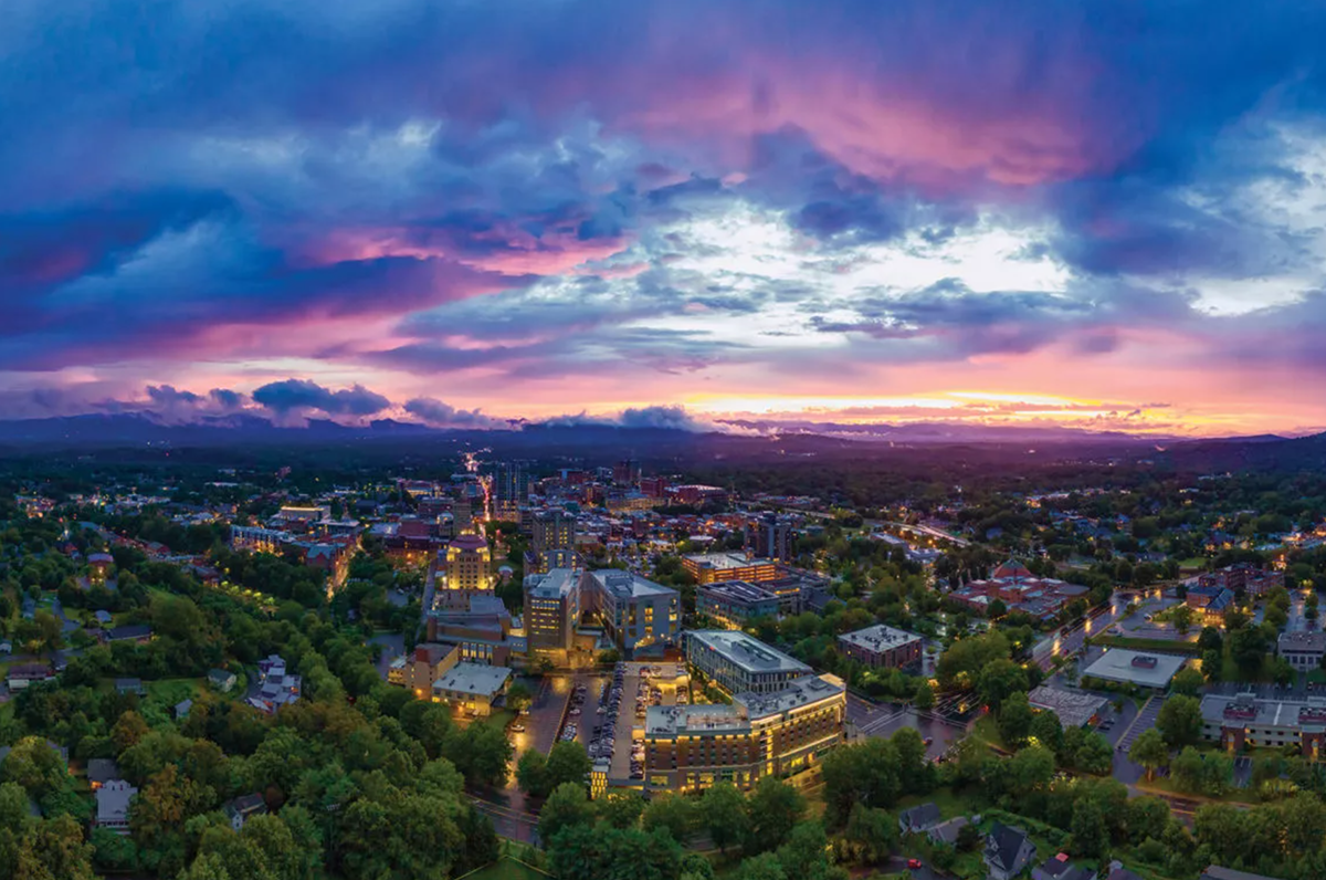 aerial photo of downtown Ashville, North Carolina with sunset in background