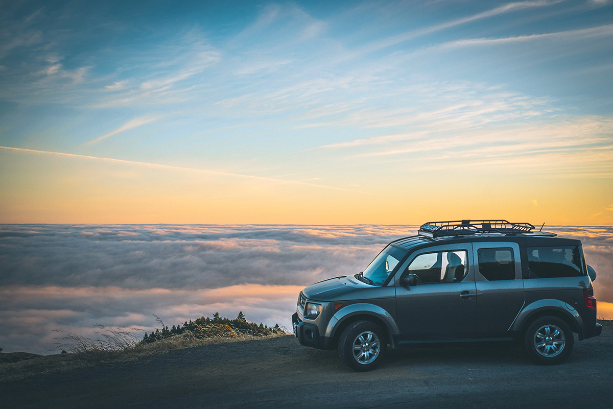 Car parked overlooking a sunset on a road trip vacation