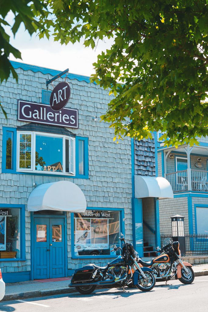 Exterior of blue building with art galleries sign hanging above door