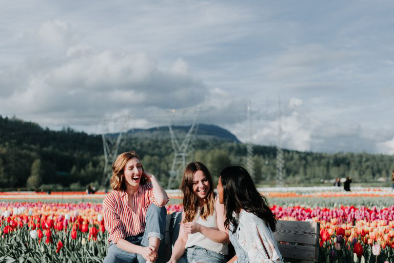 a group of friends in a flower field on a last minute group vacation