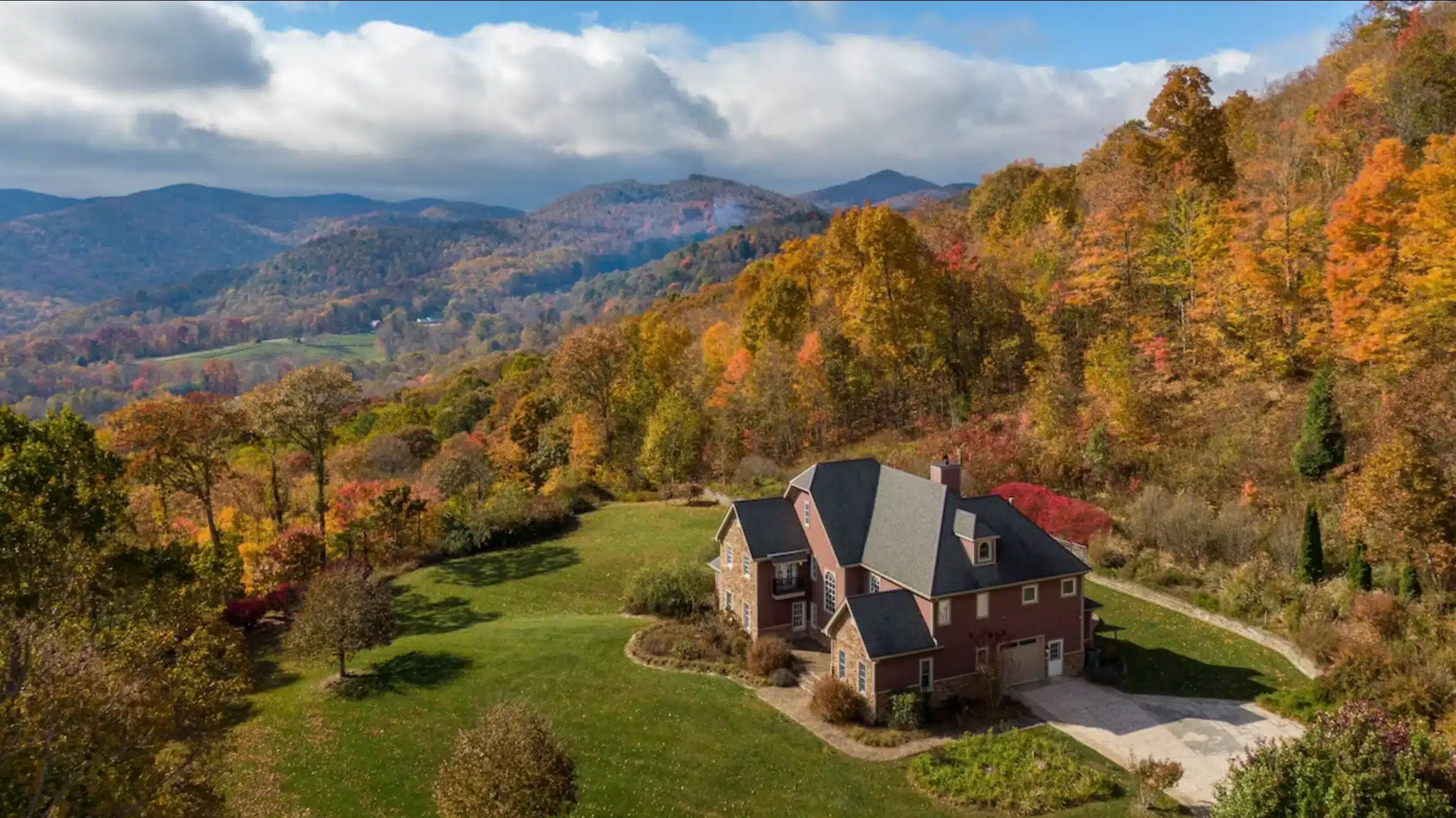 Find the best last minute vacation rentals on Whimstay including this affordable cabin rental in the woods surrounded by fall colors and lush landscaping