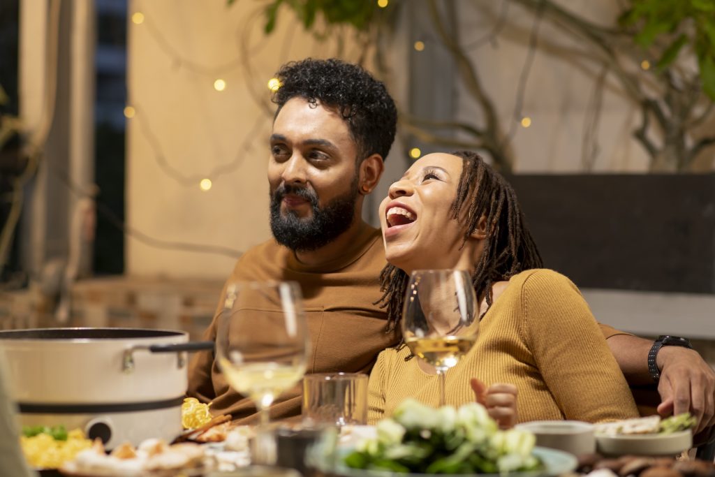 Couple laughing at a dinner table.