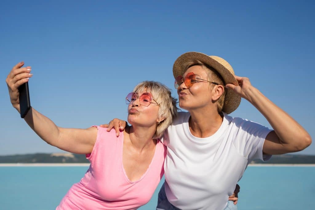 Two women taking a photo on the beach