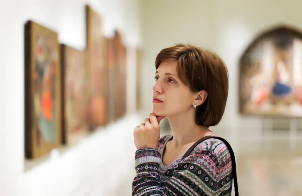 Woman looking at paintings in a museum