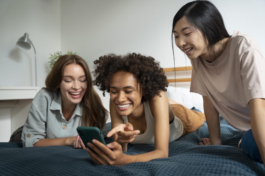 Three friends looking at their phones together
