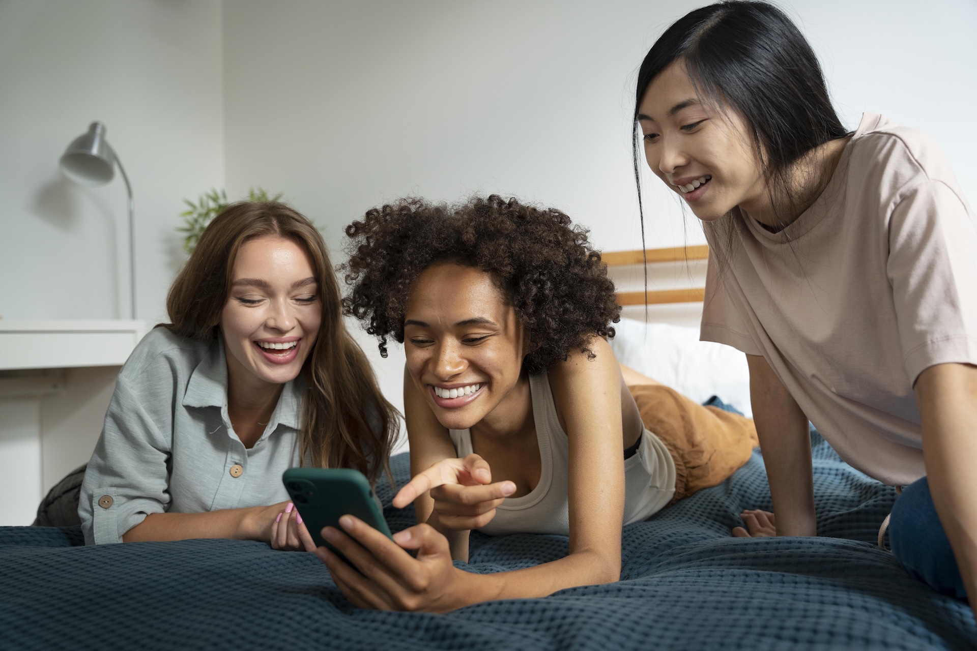 Three friends looking at their phones together