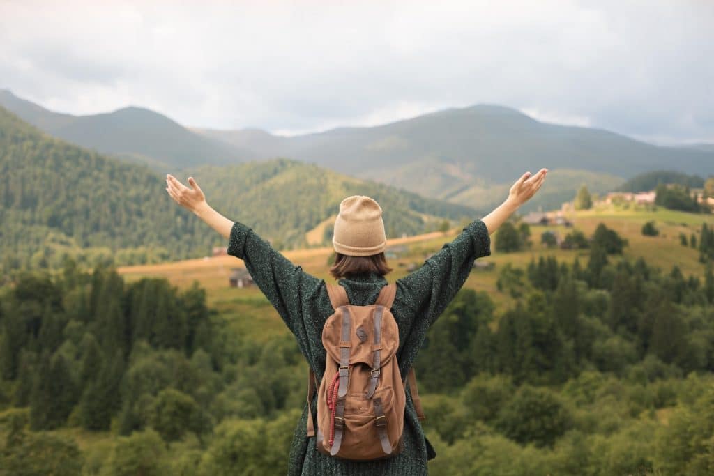 Woman looking at mountains with arms outstretched.