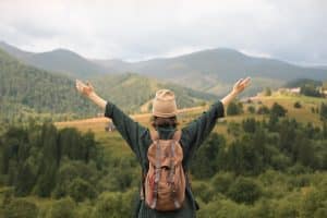 Woman looking at mountains with arms outstretched.