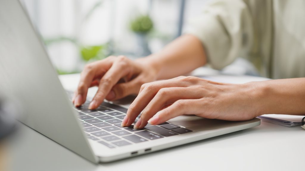 hands typing on a laptop