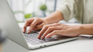 hands typing on a laptop