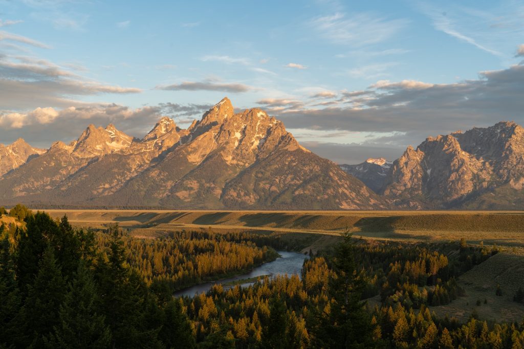 Mountains with the sun shining on a river below.