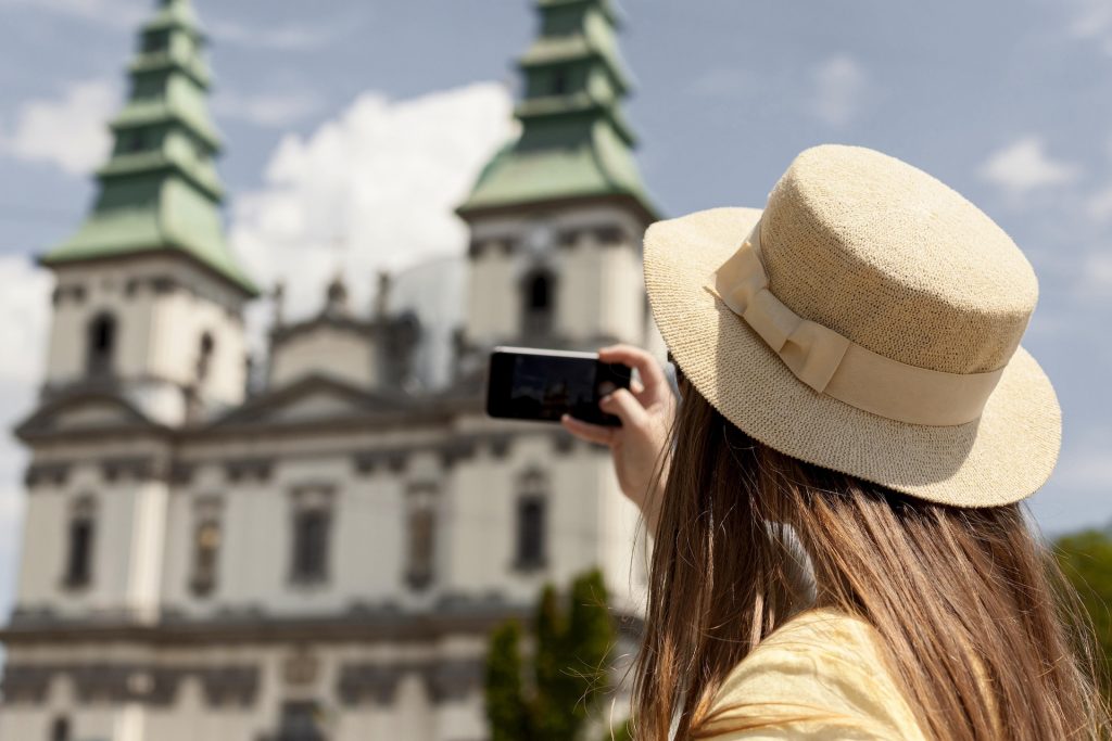 Woman taking a selfie in front of a monument.