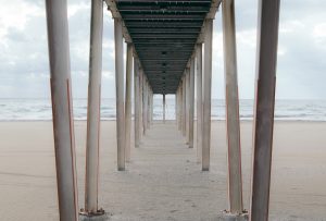 Under a wooden pier on the beach