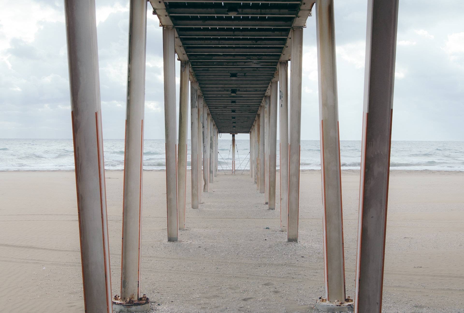 Under a wooden pier on the beach